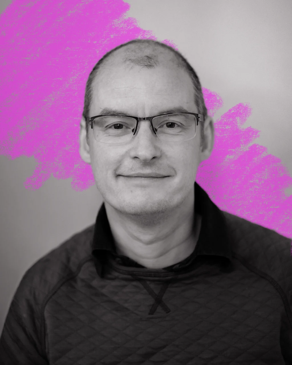 A close up black and white portrait of a man with short hair and glasses. Behind him is a hand-drawn scribble in neon pink.