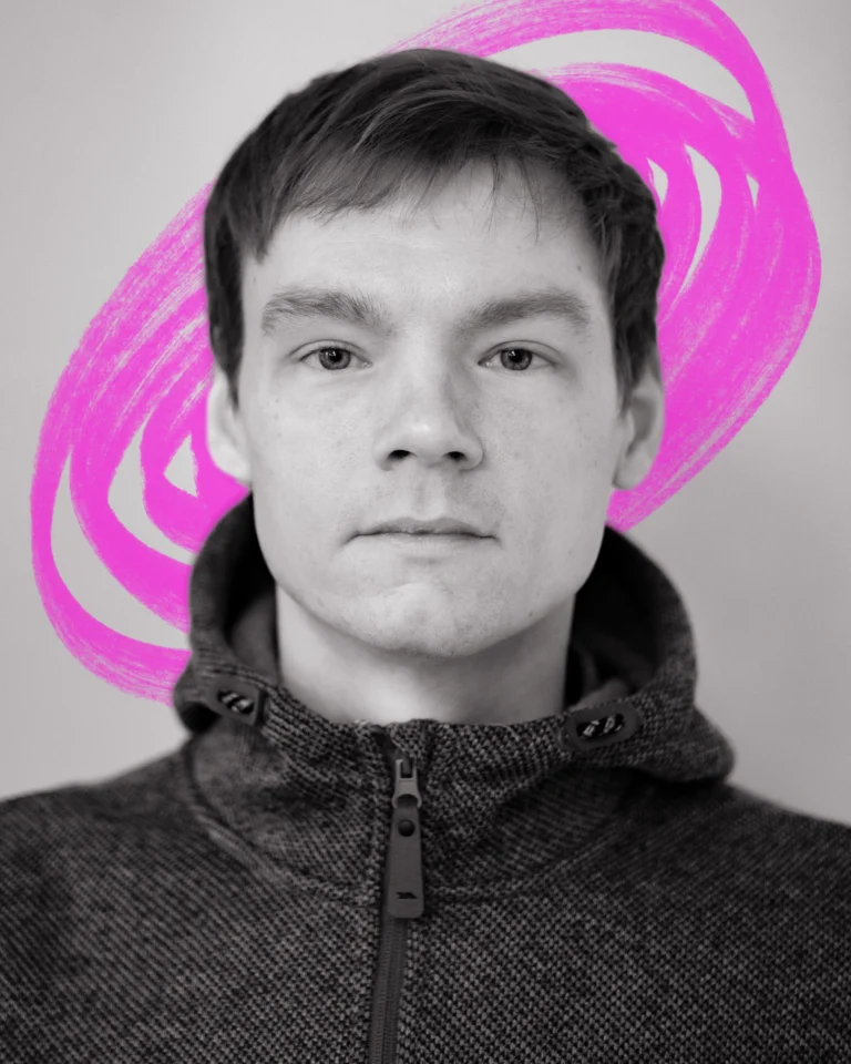 A close up black and white portrait of a man with a short cropped haircut, staring straight into the camera. Behind him is a hand-drawn scribble in neon pink.
