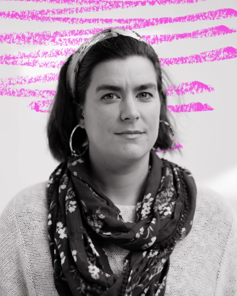 a medium wide portrait of a women with short dark hair pushed back with a hairband. She's wearing a loosely wrapped scarf on top of a jumper. behind her is a hand-drawn neon scribble.