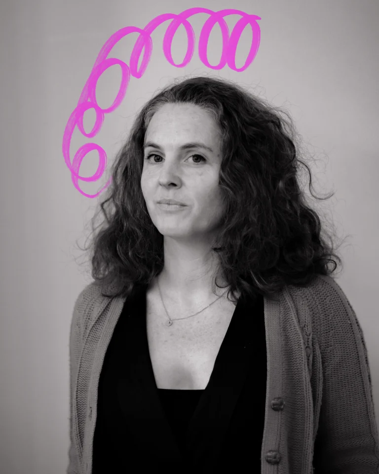 a medium-wide portrait of a woman with shoulder length wavy hair, wearing a cardigan with a black shirt underneath. Above her is a hand-drawn neon scribble.