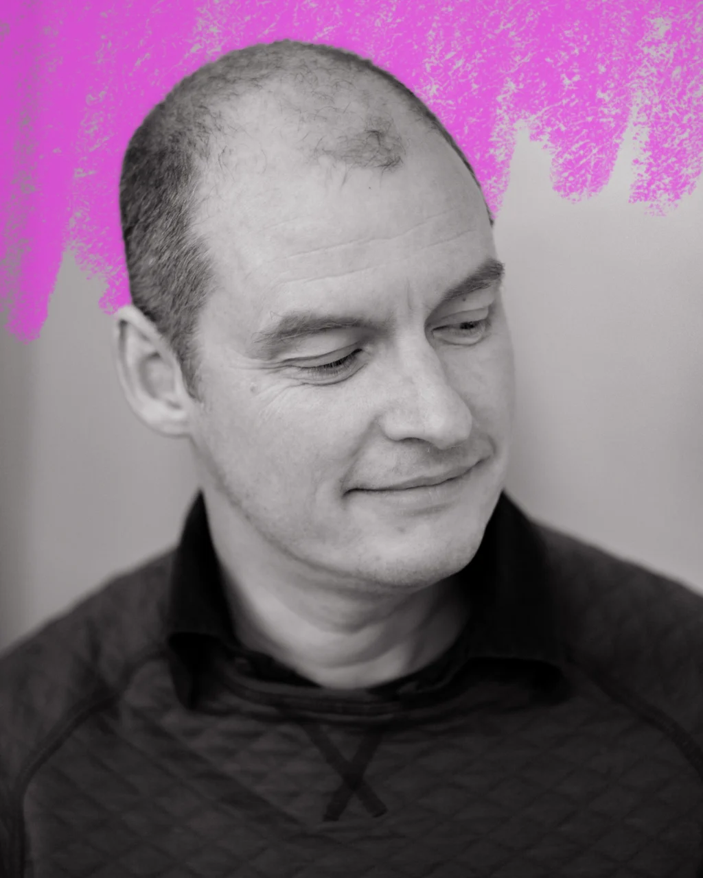 a close up portrait of a man with short hair looking down to the right. behind him is a hand-drawn neon pink scribble.